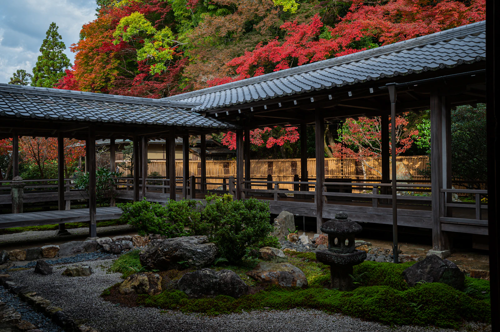 Covered wooden walkway through a Japanese garden in autumn