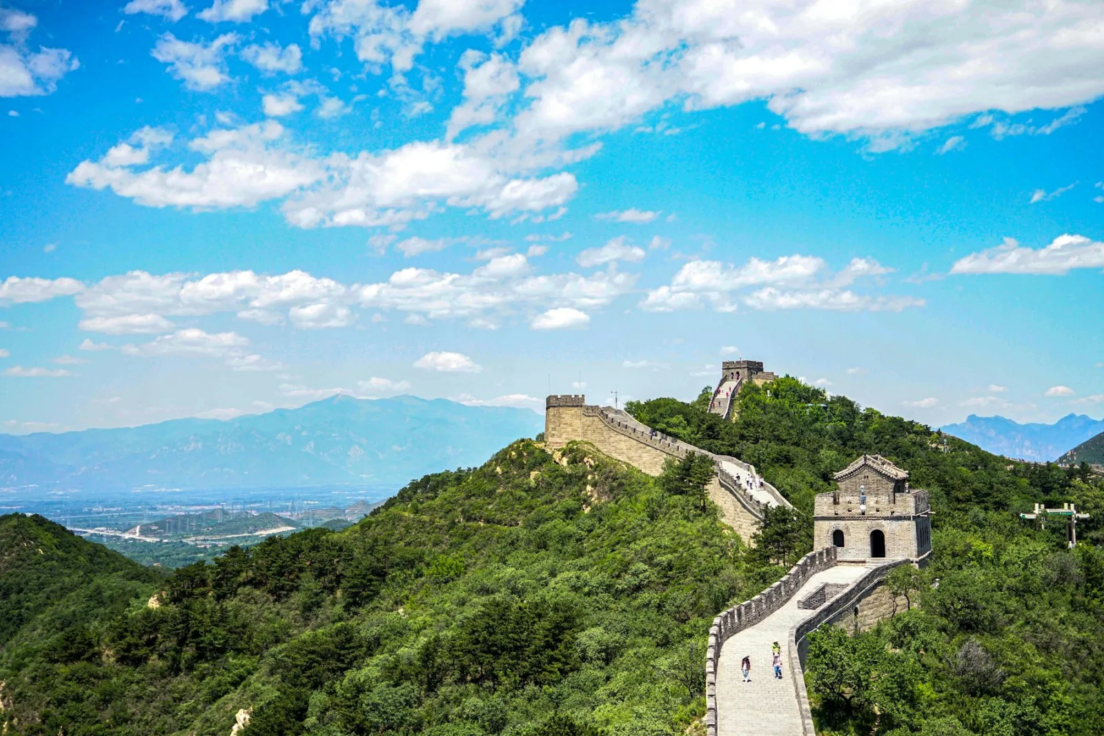 Great Wall of China winding across green mountain ridges